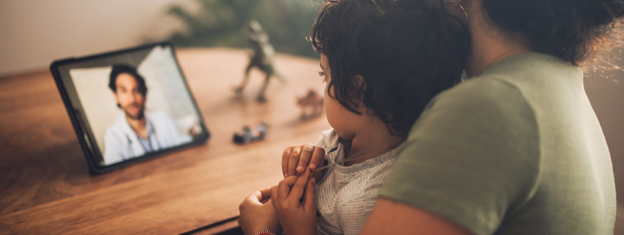 Mother and son speak to doctor with telemedicine.