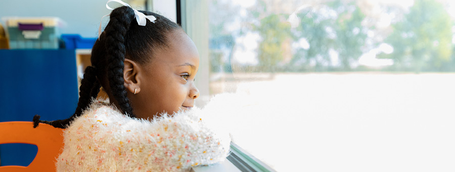 A young girl looks out a window.