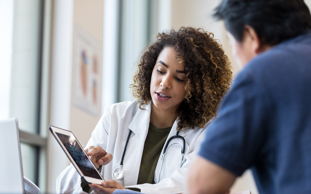 Doctors looking at patient information on a tablet.