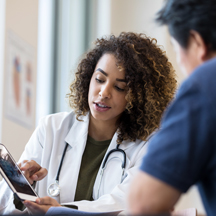 Doctors looking at patient information on a tablet.